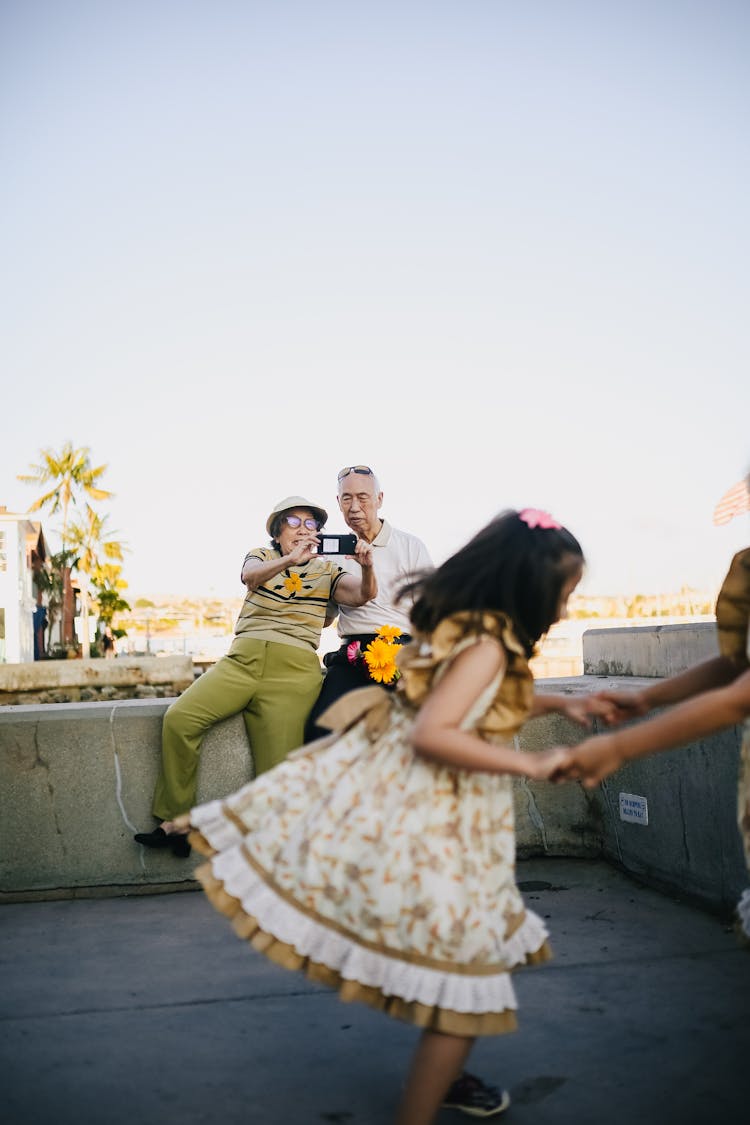 Elderly Woman Taking Photo Of Her Granddaughter