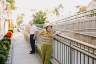 Elderly Couple Standing on the Street Leaning on the Railing