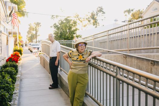 Elderly Couple Standing on the Street Leaning on the Railing