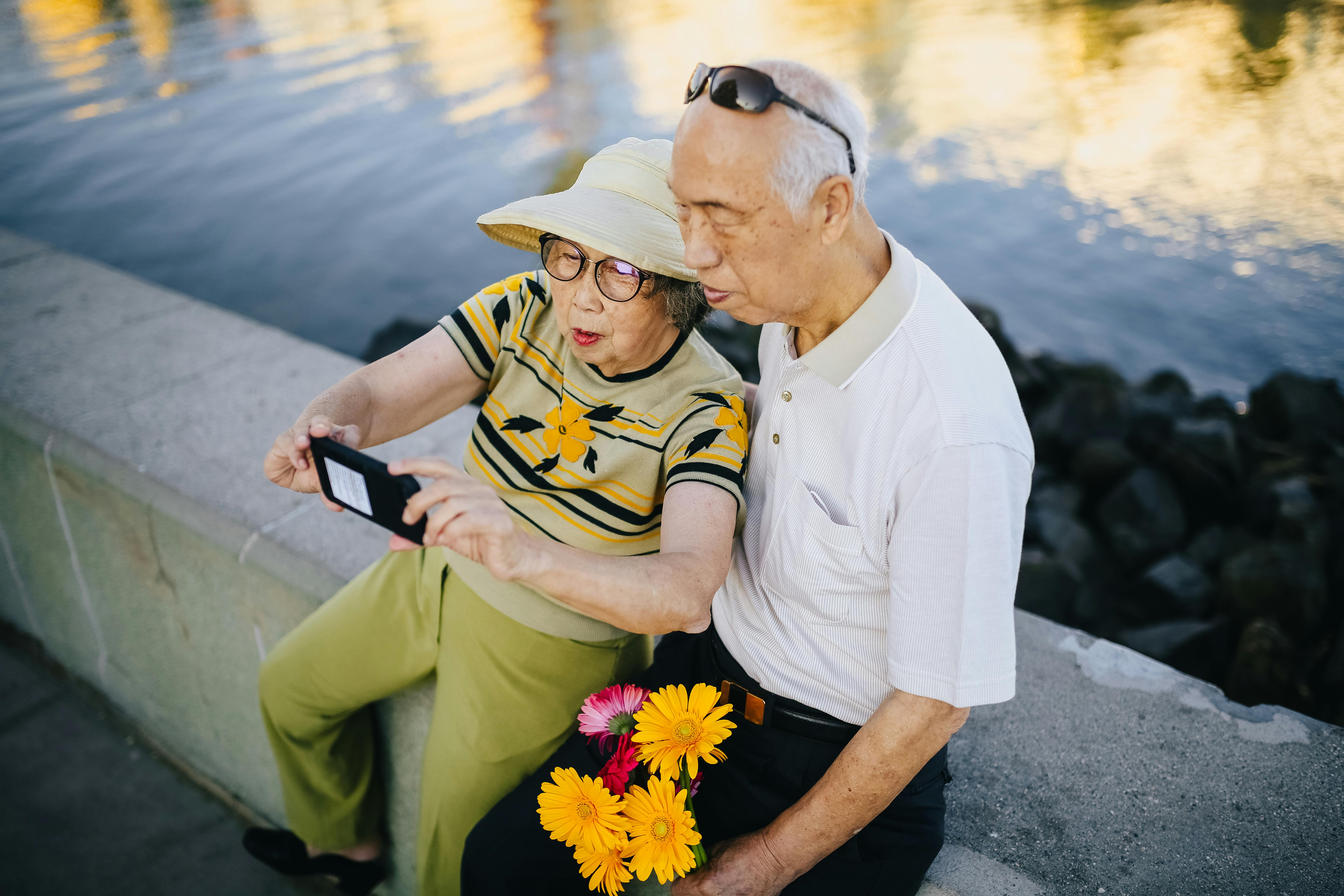 Elderly couple sitting on a concrete bench. | Photo: Pexels