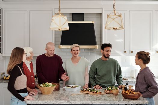 A multi-generational family enjoying a meal preparation together in a bright kitchen.