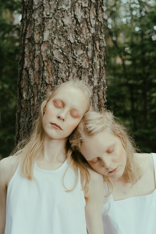 Women with Eyes Closed Leaning on Tree Trunk