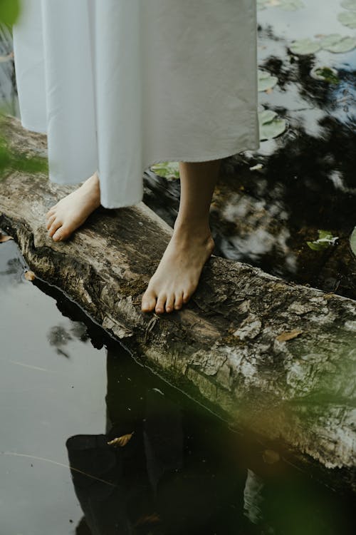 Woman Standing Barefoot on Wood on Lake