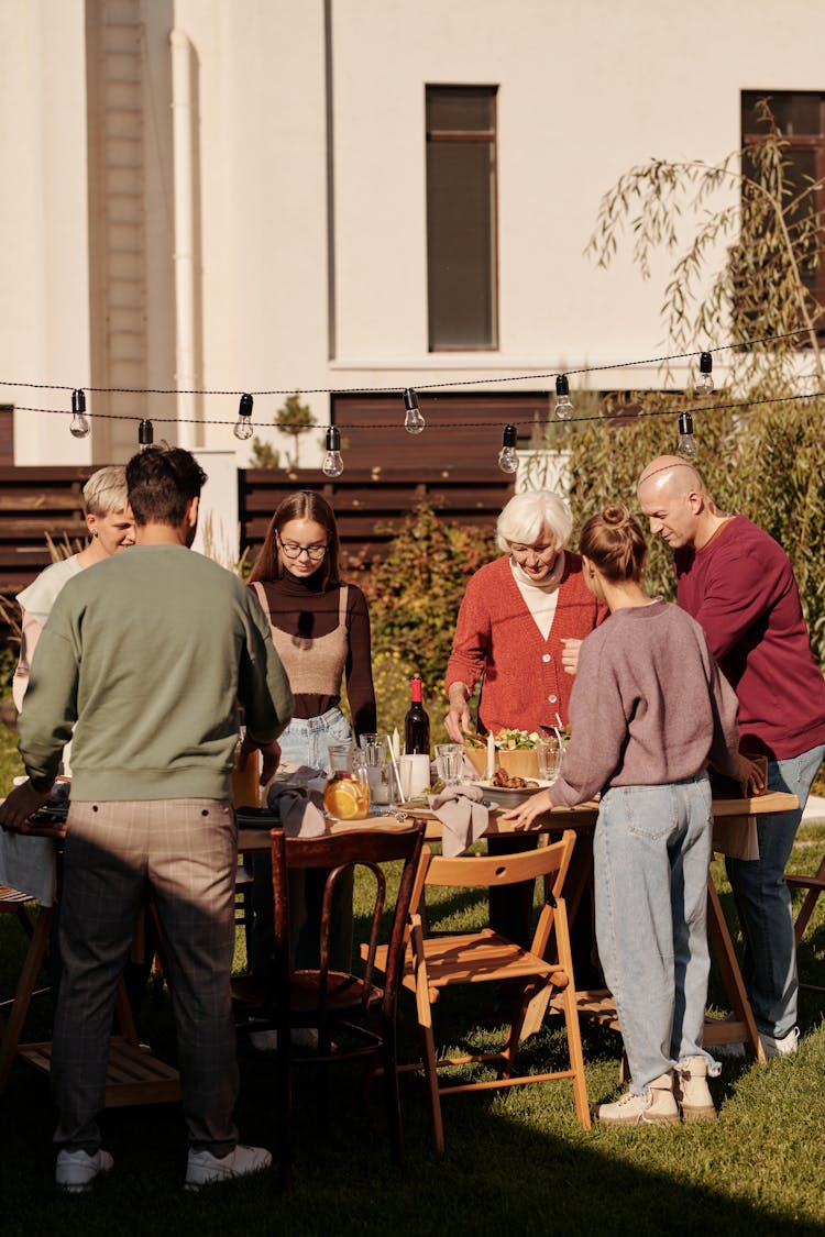 A Group Of People Gathering In The Backyard