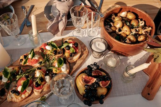 A beautifully set outdoor dining table featuring an array of fresh vegan dishes under sunlight.