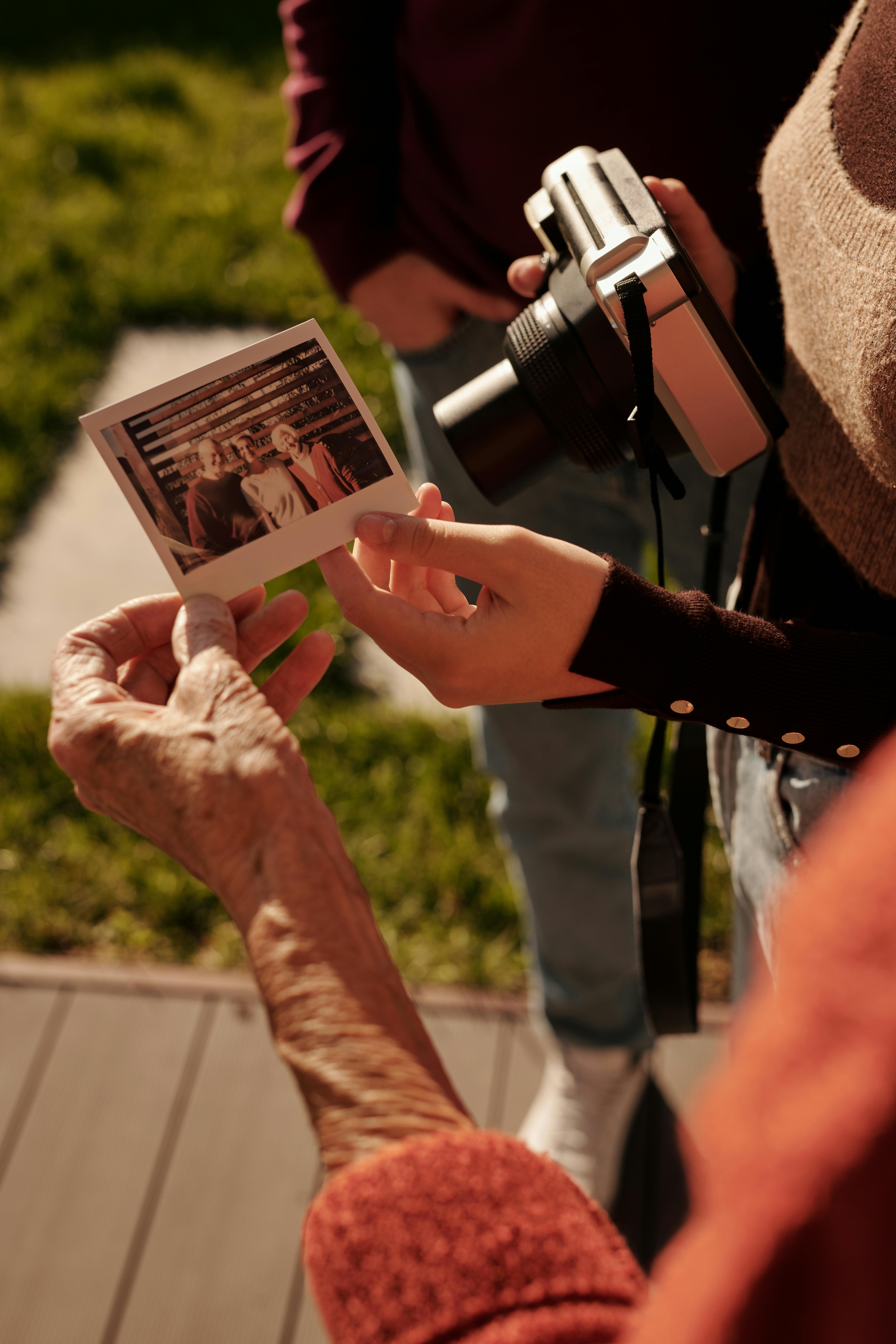 一群人在户外分享一张宝丽来照片