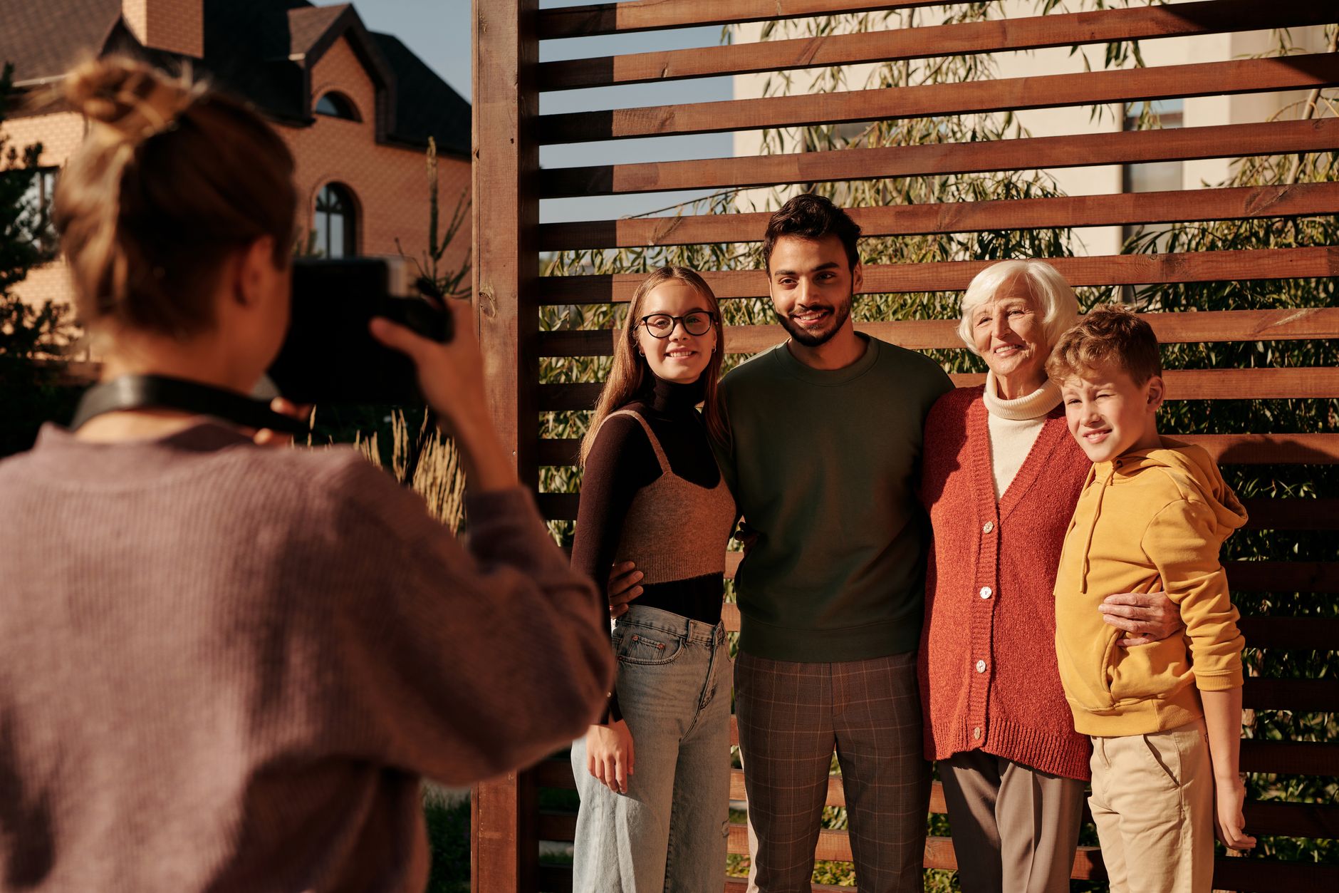 A cheerful family posing outdoors for a photograph on a sunny day, capturing generations together in harmony.