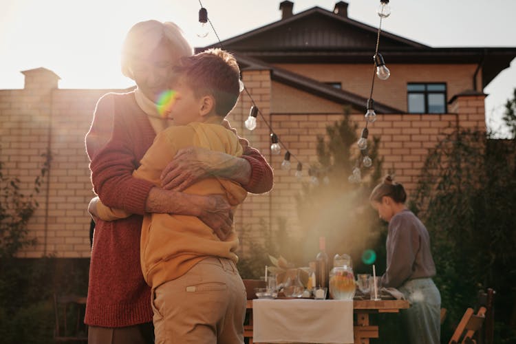 Elderly Woman Hugging A Boy