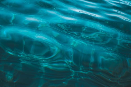Overhead view of abstract background representing transparent sea aqua with ripples on shiny surface