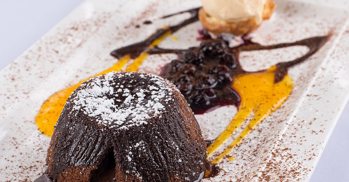 close-up of a gooey chocolate air fryer mug cake with a molten center and powdered sugar dusting