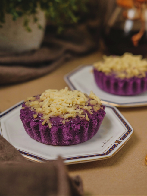 A vibrant purple yam cake elegantly presented on a decorative plate.