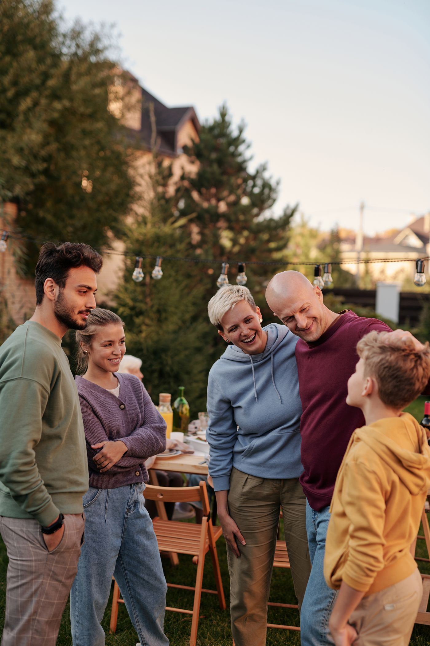 Three generations of a family gathered for dinner in a garden behind their house, photo by Askar Abayev on Pexels