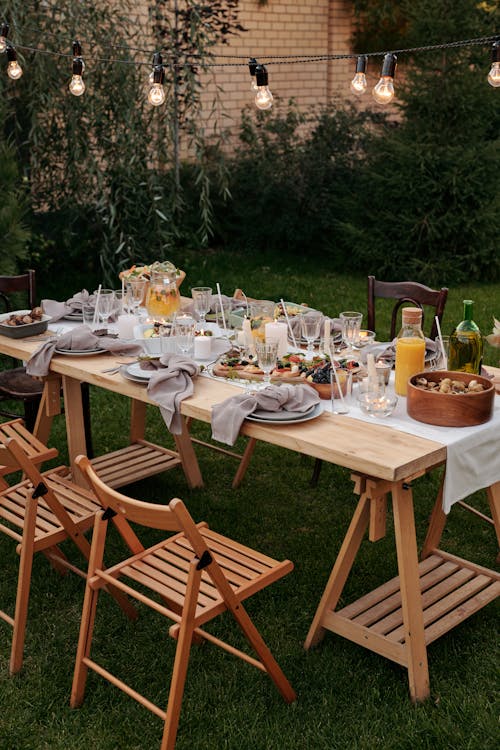 Free Food on Brown Wooden Table With Chairs and Plates Stock Photo