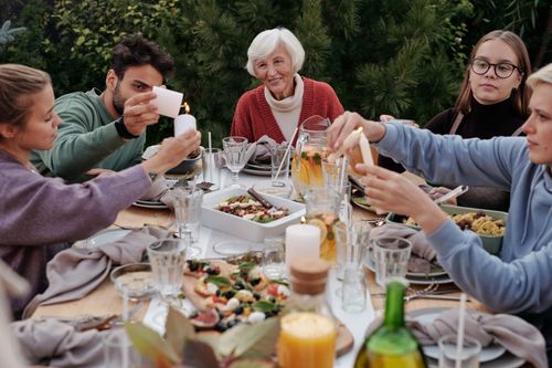 Free A family enjoys an outdoor autumn gathering with food, drinks, and candles. Stock Photo