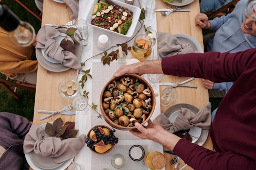 Overhead view of a festive family dinner with a seasonal meal spread on a wooden table.