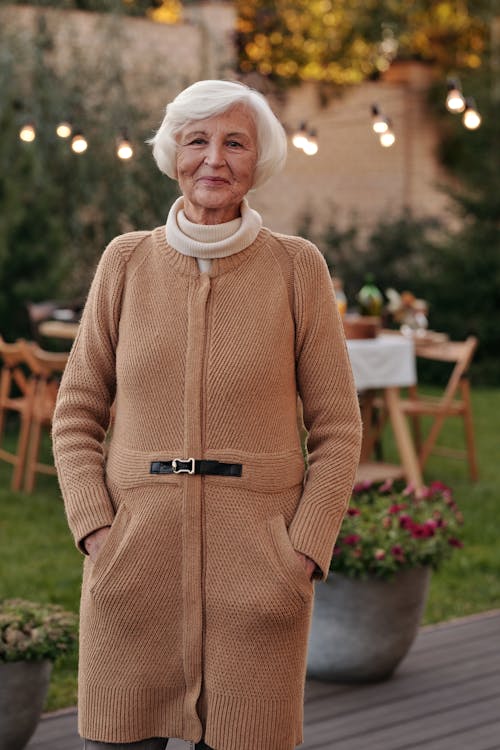 бесплатная Пожилая женщина, стоящая в саду Стоковое фото