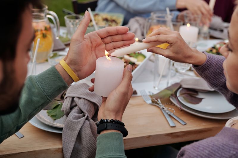 Neighbours sharing a candlelit dinner around a long table — photo by Askar Abayev on Pexels
