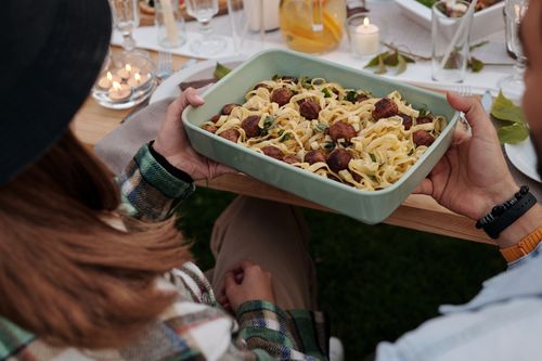 Free Aerial view of a delicious pasta and meatball dish being served at a cozy outdoor gathering. Stock Photo