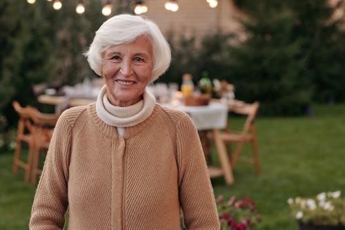 Happy elderly woman with gray hair laughing and looking at camera in terrace