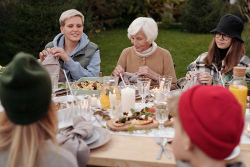 Cheerful family enjoying dinner party together in countryside