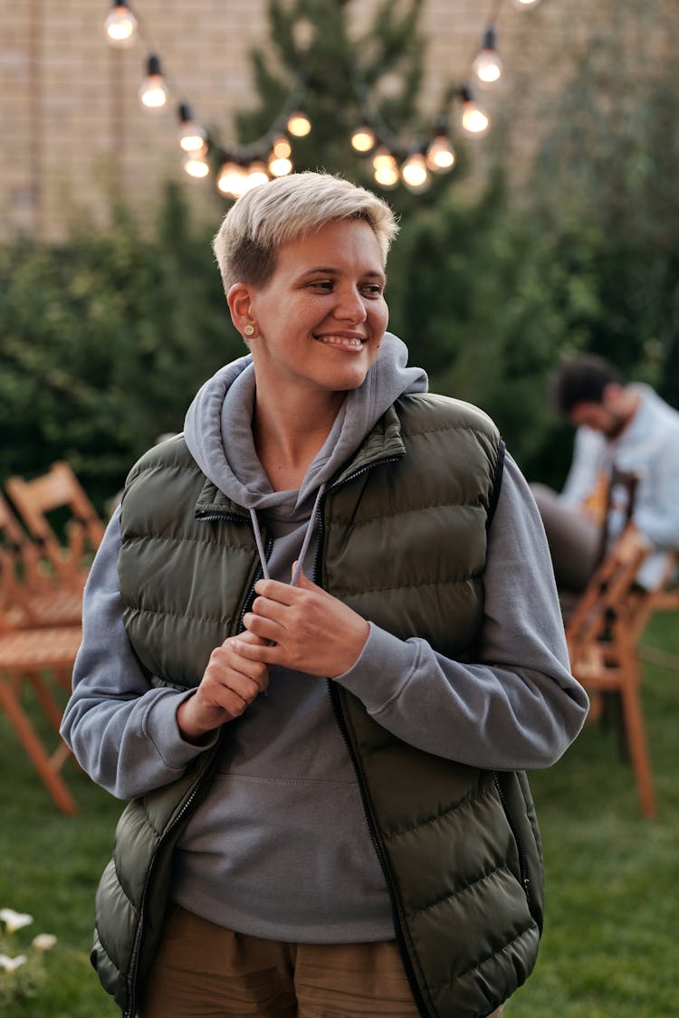 Young Woman In Warm Cloth Smiling During Outdoors Party