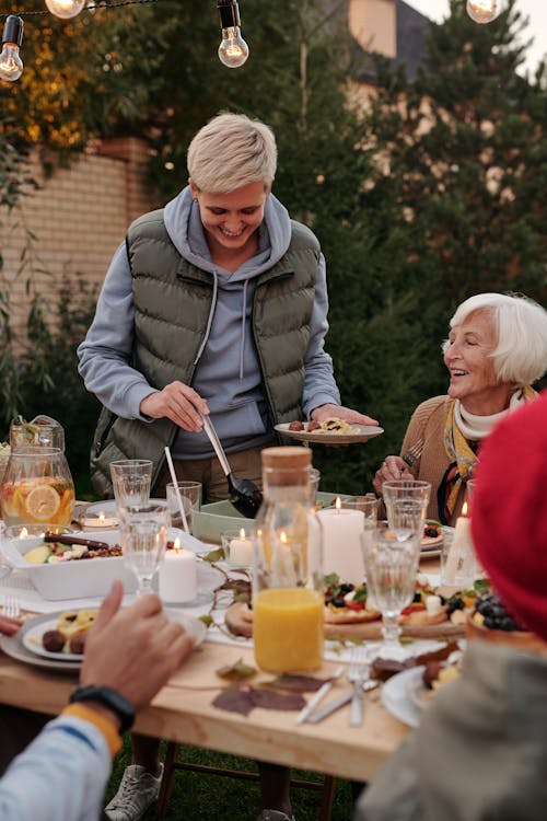 A Woman in Gray Jacket Getting Food on the Table