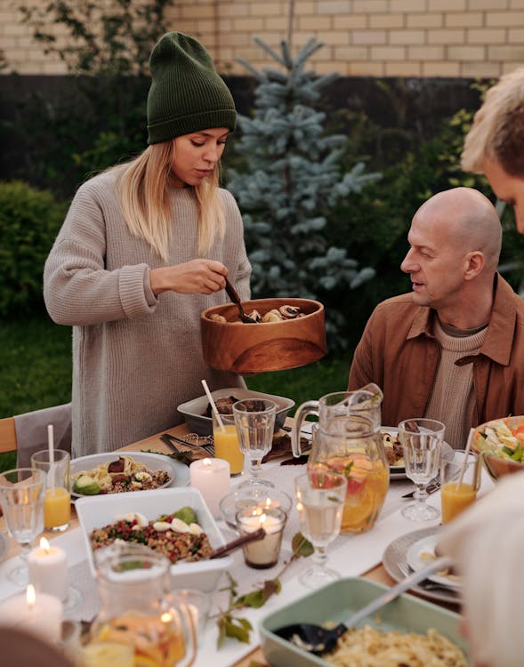 Free Man and Woman Sitting on Chair in Front of Table With Food Stock Photo