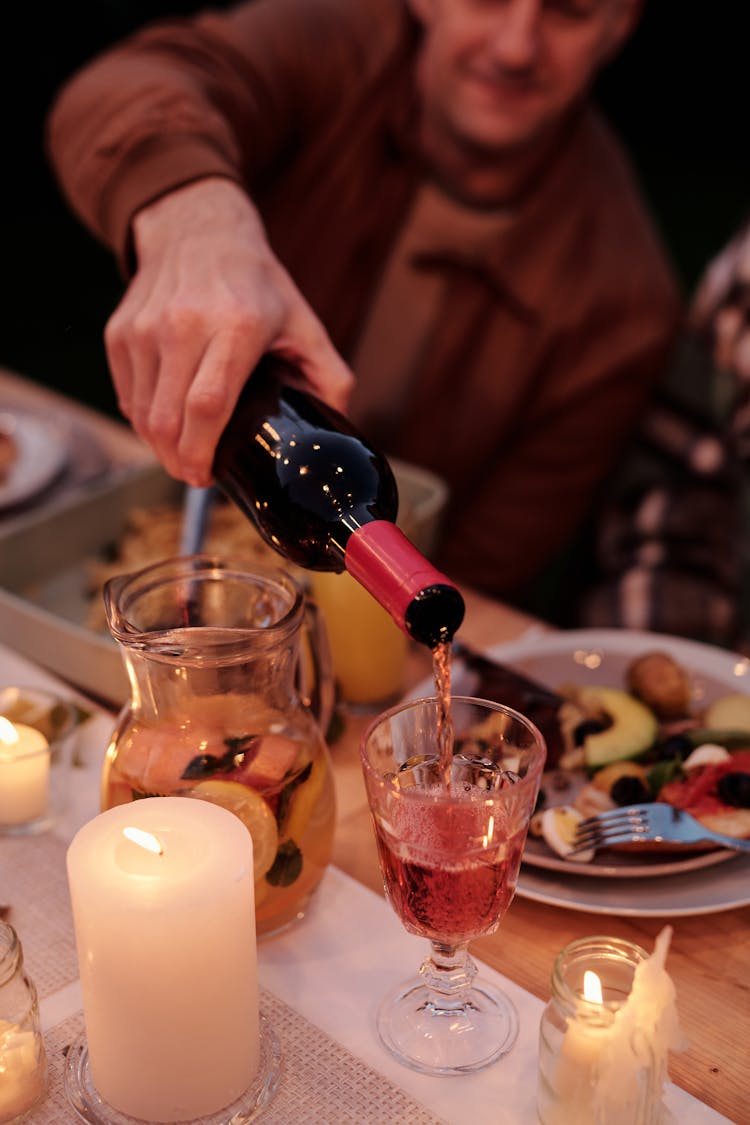 Crop Person Pouring Wine In Glass On Family Dinner