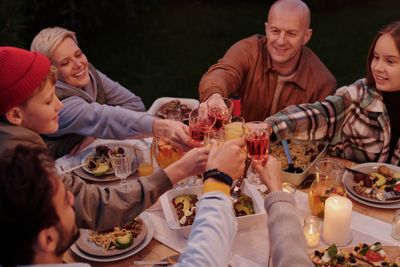 Group raising glasses at an evening dinner — photo by Askar Abayev on Pexels