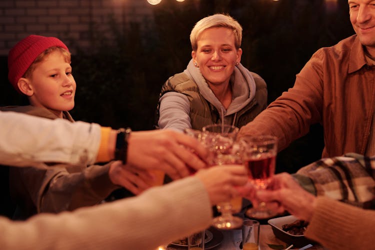 Laughing Family Toasting At Dinner In Garden