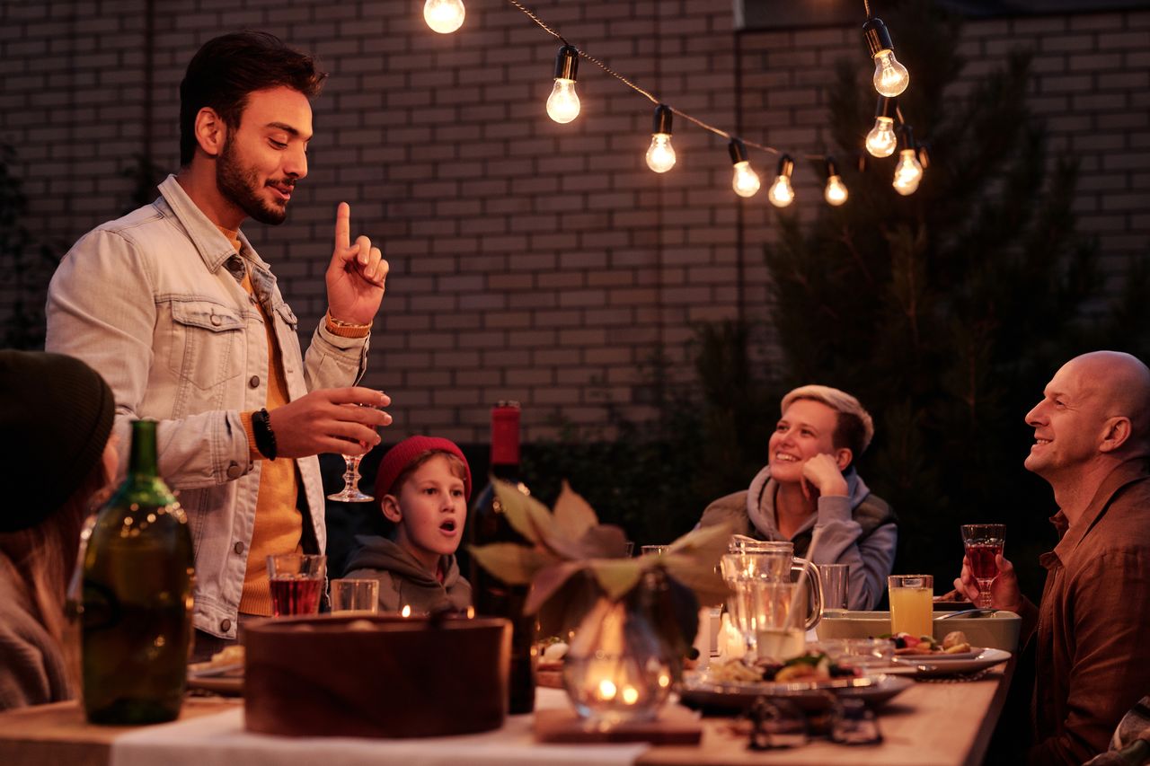 Guests laughing together at a backyard dinner