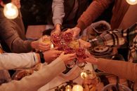 朋友们在烛光晚餐桌上热情举杯，共饮葡萄酒