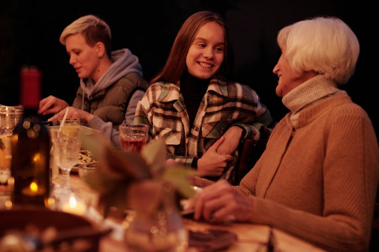 Loving Family Chatting During Dinner In Garden