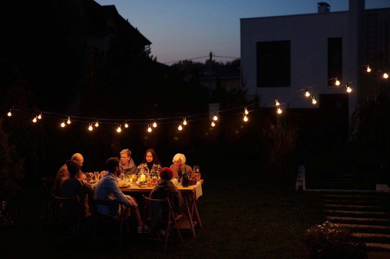 A wide view of a dinner party at night