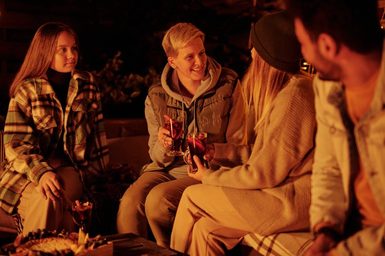 Cheerful Friends With Mulled Wine At Bonfire In Garden