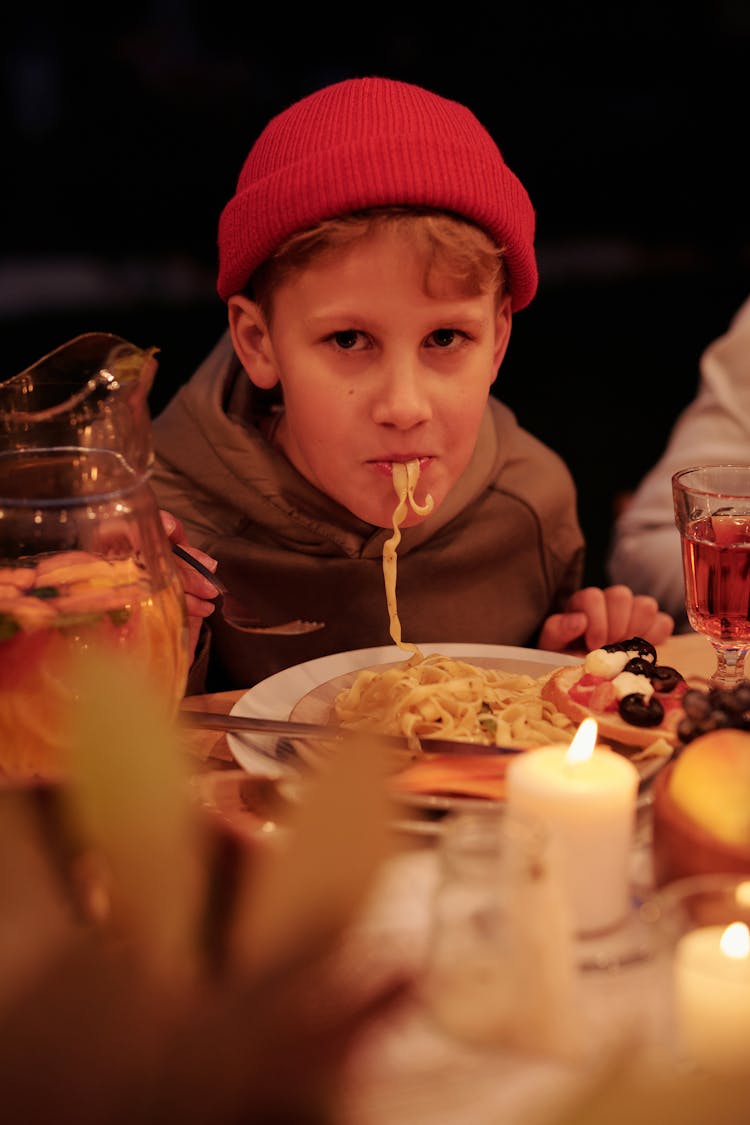 Boy Having Pasta During Family Dinner