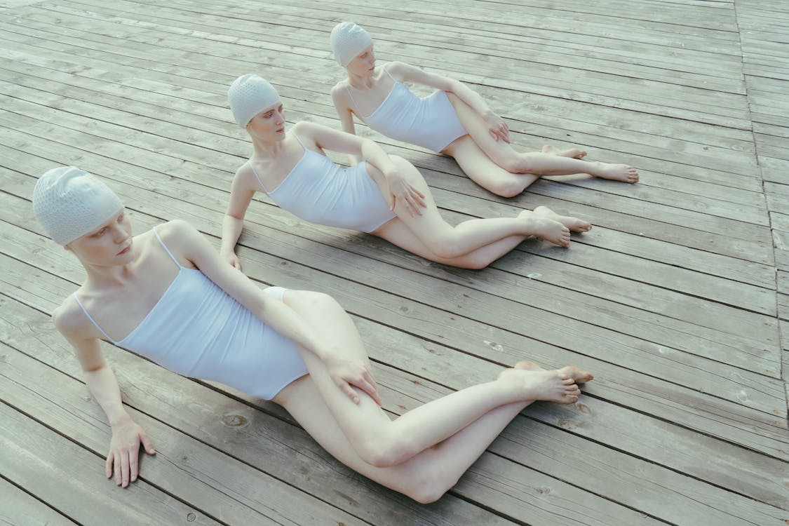 Women in Swimsuits Lying on a Wooden Floor 