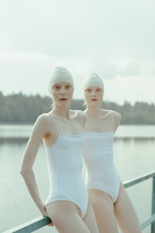 Two Women Wearing White Swimsuit