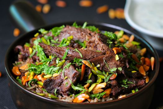 Delicious beef and rice dish topped with fresh herbs and assorted nuts, perfect for gourmet meals.