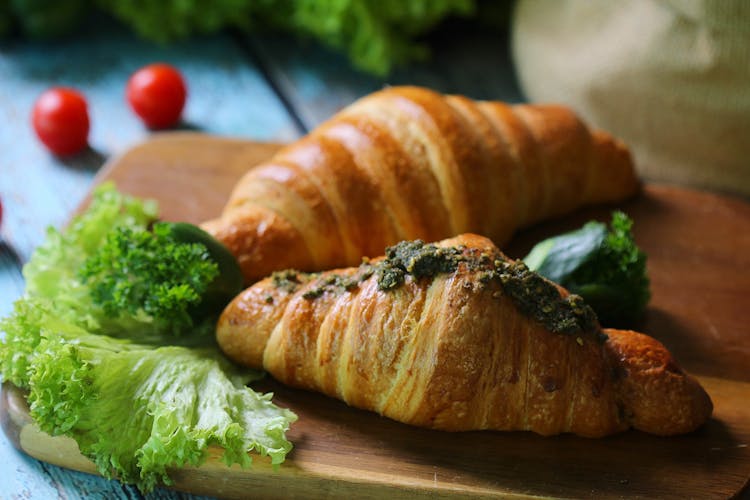 Two Croissants On A Wooden Serving Board