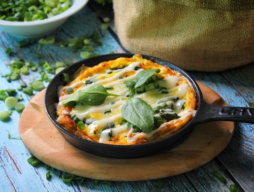 Free A tempting baked casserole topped with fresh basil leaves in a cast iron skillet, perfect for food photography. Stock Photo