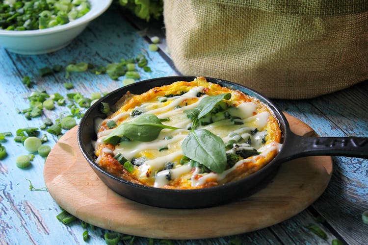 Scrambled Eggs With Green Onions On Black Skillet Pan