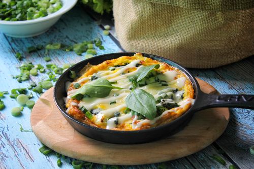 Free Delicious homemade frittata in a skillet, garnished with fresh spinach and cheese, perfect for brunch. Stock Photo
