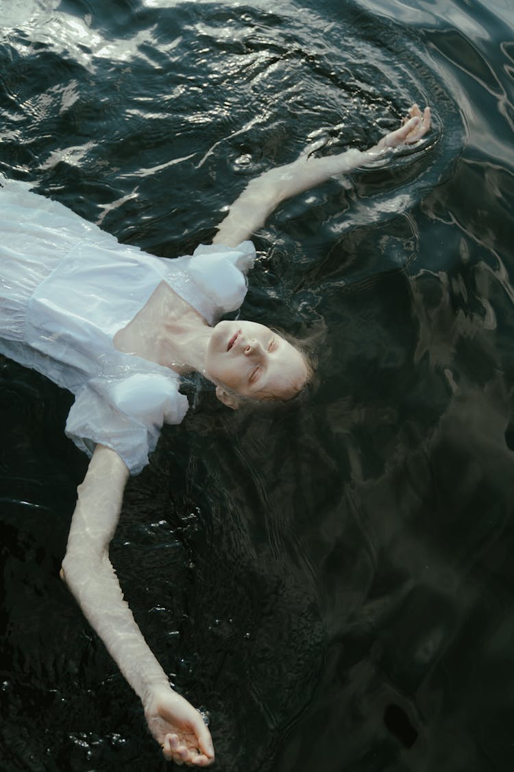 A Woman In White Dress Floating In Water