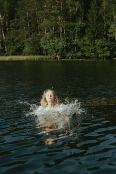 一名女子在宁静的森林湖中，沐浴着日光，享受清爽的游泳和戏水