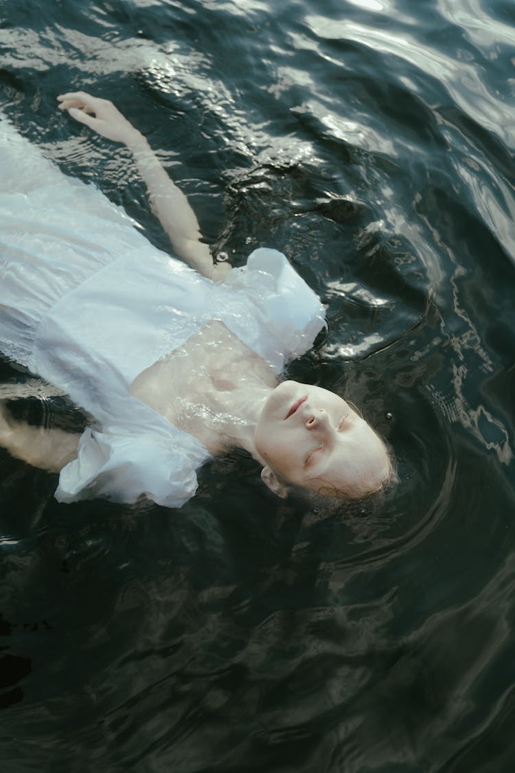 A Woman In White Dress Floating In Water