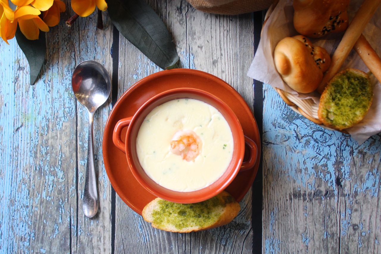 A bowl of creamy Irish seafood chowder served with bread on a rustic table