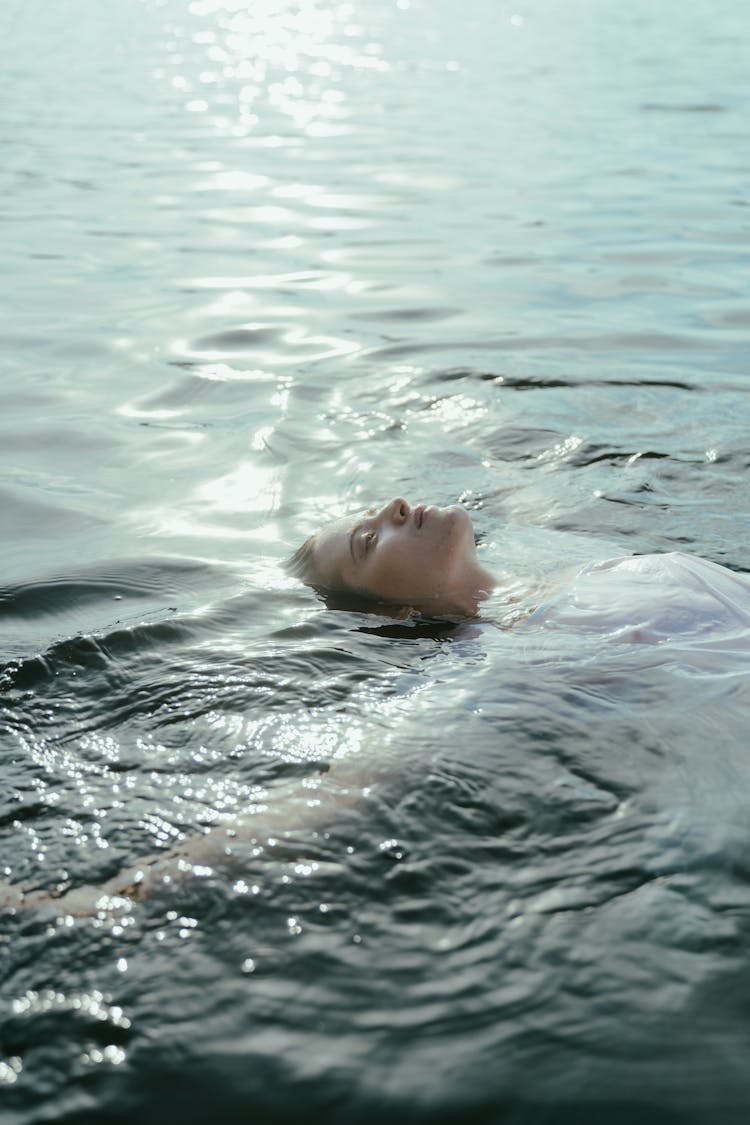 Woman Wearing White Dress Floating In A Lake