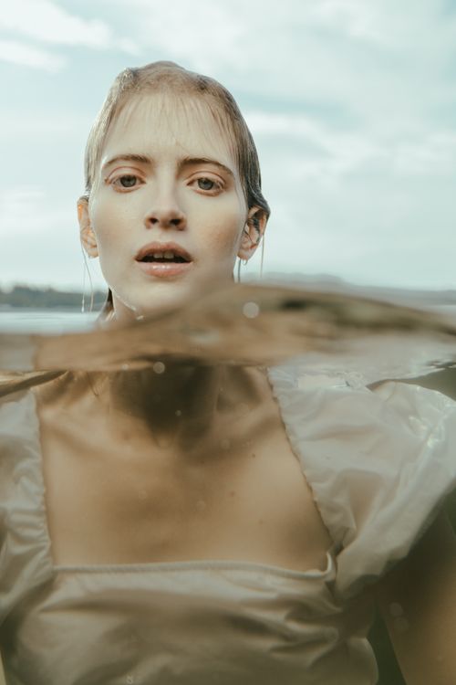 Free A captivating portrait of a woman in water, merging elements of fantasy and reality. Stock Photo