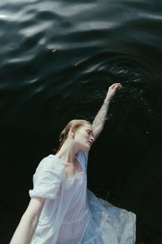 一袭白裙的优雅女子，在漆黑的水面上优雅地漂浮，营造出宁静而艺术的景象